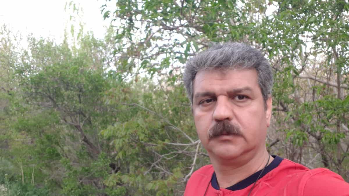 تصویری از رضا شهابی، کارگر اخراجی اتوبوسرانی تهران و عضو هیئت مدیره سندیکای کارگران اتوبوسرانی - در زندان اوین زندانی است. پشت سر او در تصویر درختان سیز دیده میشود