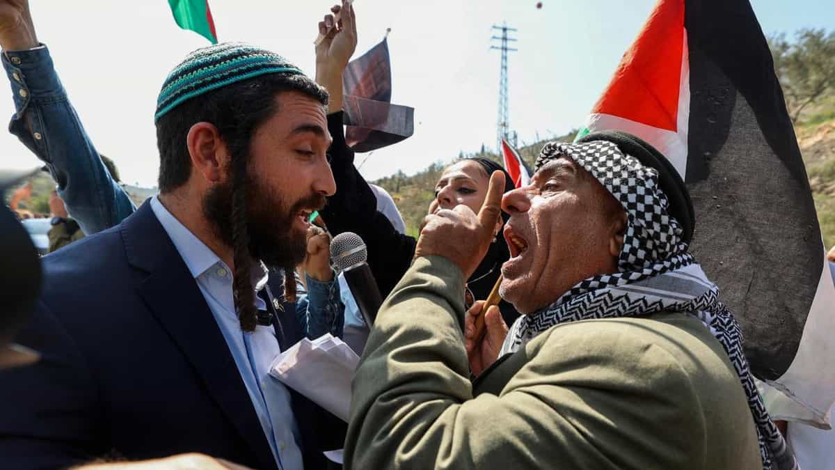 یک نماینده مجلس اسرائیل سعی می‌کند مانع از تظاهرات فلسطینیان در اعتراض به خشونت شهرک‌نشینان در روستای حواره در کرانه باختری شود / منبع: AFP