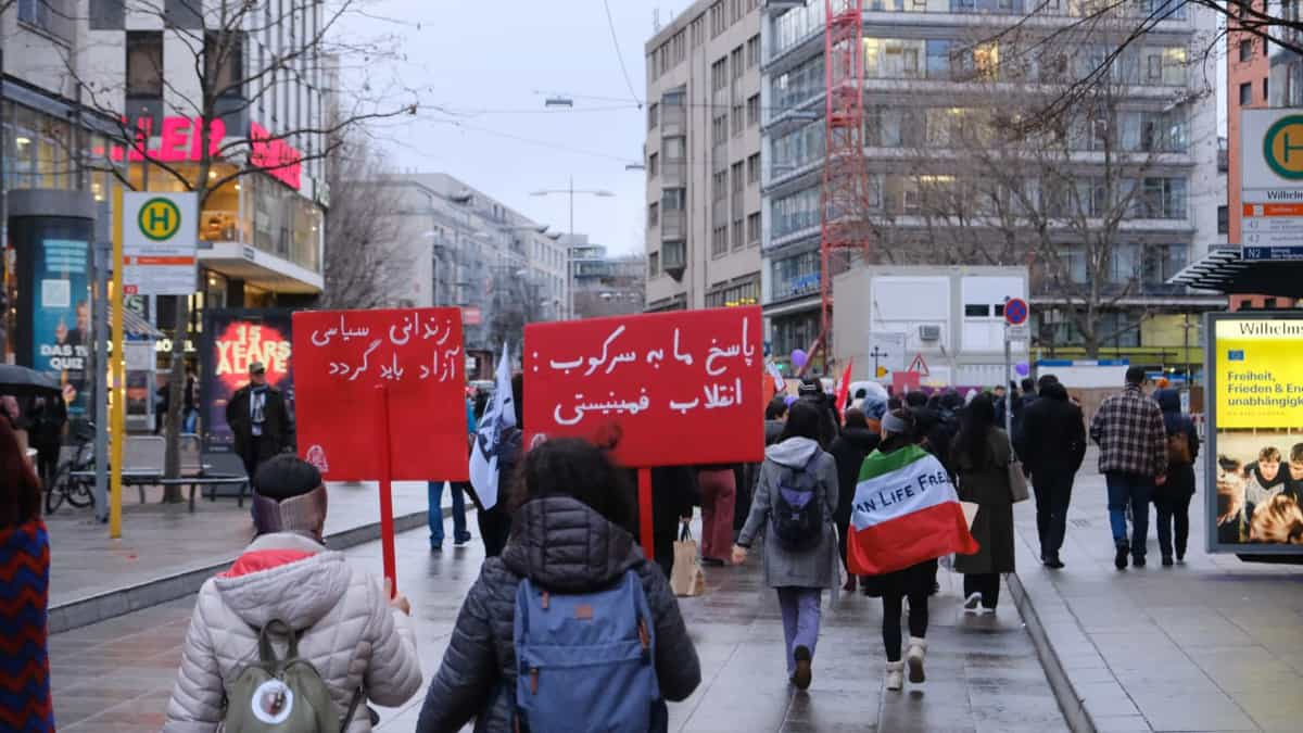 دو زن در راهپیمایی ۸ مارس ۲۰۲۲ شبکه‌ی فمینیست‌ها برای ژینا در اشتوتگارت آلمان با پلاکاردهایی با این متن‌ها: پاسخ ما به سرکوب، انقلاب فمنیستی و زندانی سیاسی آزاد باید گردد.