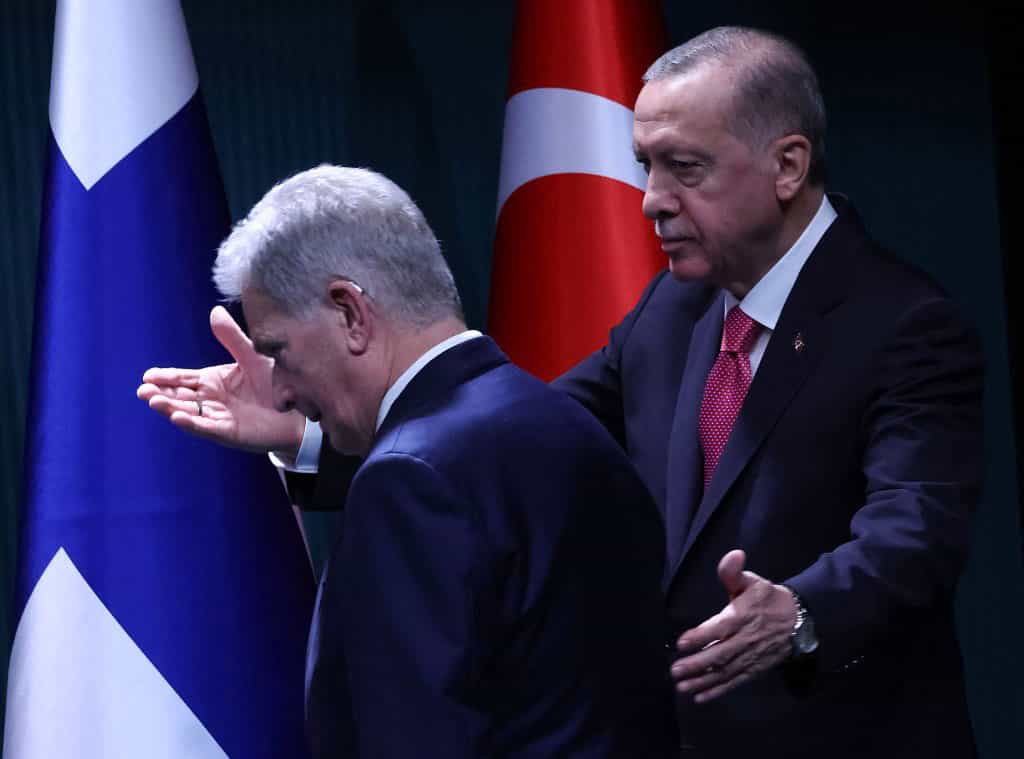 رجب طیب اردوغان، رئیس جمهوری ترکیه هنگام ورود به سالن نشست خبری مشترک دستاش را پشت سائولی نیینیستو، رئیس جمهوری فنلاند قرار داده و با دست دیگر به او تعارف میکند تا وارد سالن شود.