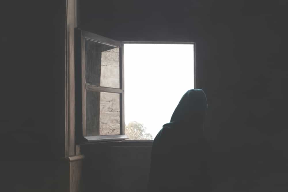 زنی محجبه پشت یک پنجره باز
