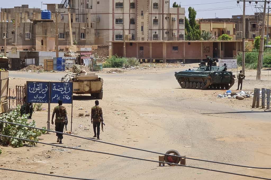 سربازان ارتش سودان در ۶ مه ۲۰۲۳ در نزدیکی خودروهای زرهی مستقر در خیابانی در جنوب خارطوم در میان نبردهای مداوم علیه نیروهای پشتیبانی سریع شبه نظامی قدم میزنند. - حملات هوایی در ۶ می پایتخت سودان را هدف قرار داد. درگیریها تنها چند ساعت قبل از اینکه طرفهای متخاصم قرار است برای اولین گفتگوهای مستقیم خود در عربستان سعودی با یکدیگر دیدار کنند، وارد هفته چهارم شد. (عکس از خبرگزاری فرانسه)