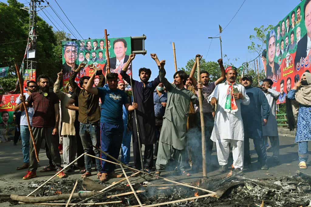 عدهای از طرفداران عمران خان، نخستوزیر سابق پاکستان در لاهور تصاویری از او در دست دارند و در میان دود ناشی از آتش زدن وسایلی در خیابان شعار سر دادهاند.