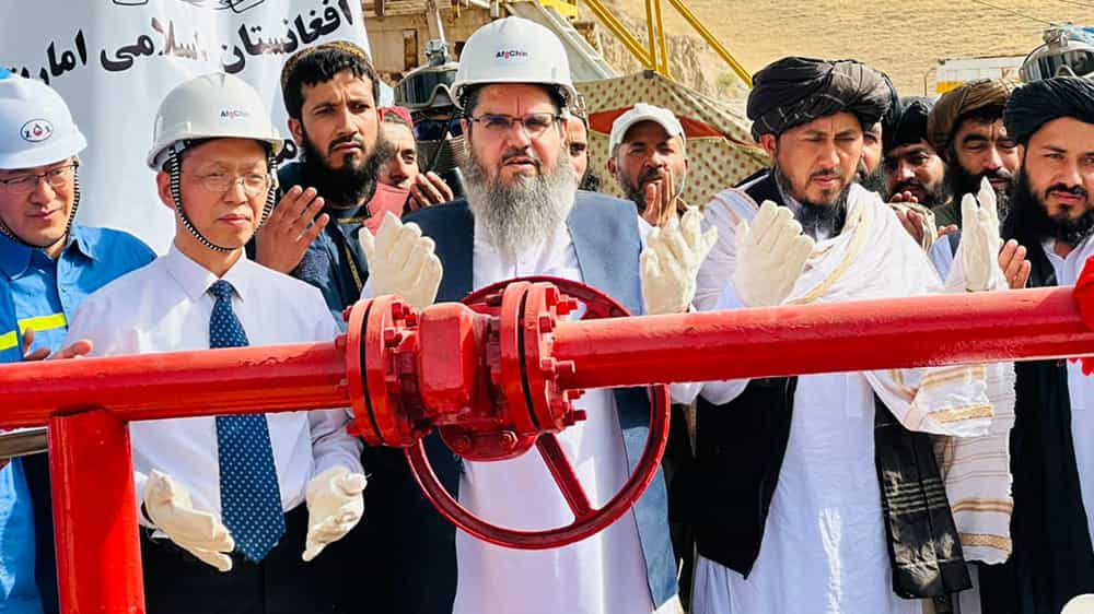 مقامات طالبان و سرمایهگذار چینی در حال دعا به هنگام آغاز استخراج یک چاه نفت