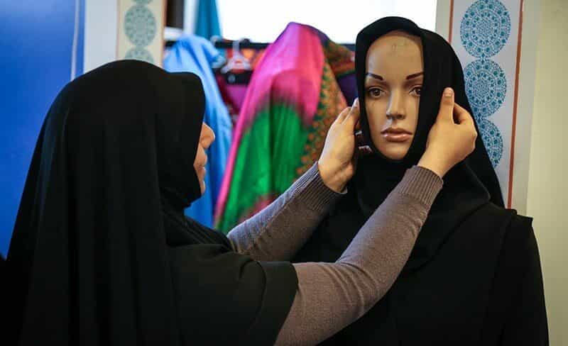 یک زن محجبه در حال «درست‌کردن» مقنعه بر سر یک مانکن - عکس از ناصر جعفری/باشگاه خبرنگاران پویا