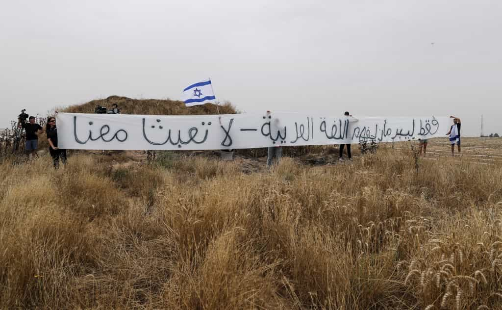 چندین اسرائیلی بنری بزرگ و پرچم اسرائیل را در دست دارند و ره به غزه گرفته اند