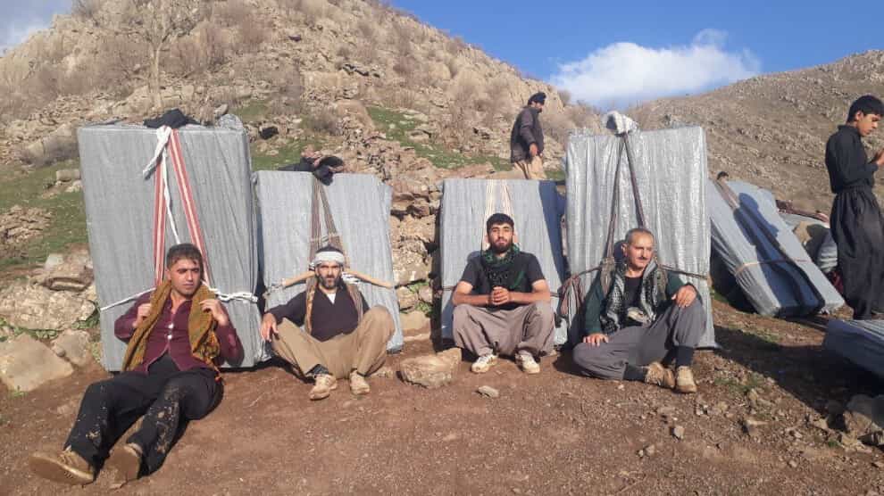 چهار کولبر با بار سنگین در حال استراحت در بلندی مرزها.