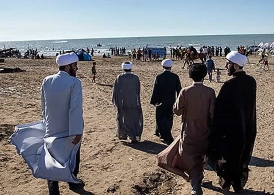 پنج آخوند در ساحل جزیره هرمز در حال قدم زدن هستند