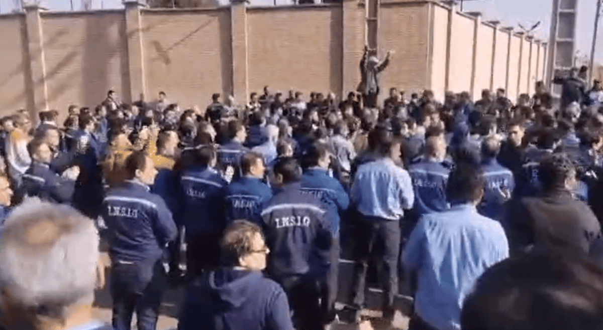کارگران در برابر شرکت تجمع کرده اند و شعار میدهند