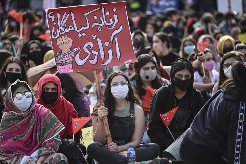 عکس مربوط به تظاهرات ۸ مارس ۲۰۲۱ زنان در اسلامآباد - جمعی از زنان روی زمین نشستهاند. (عکس از Aamir QURESHI / AFP)