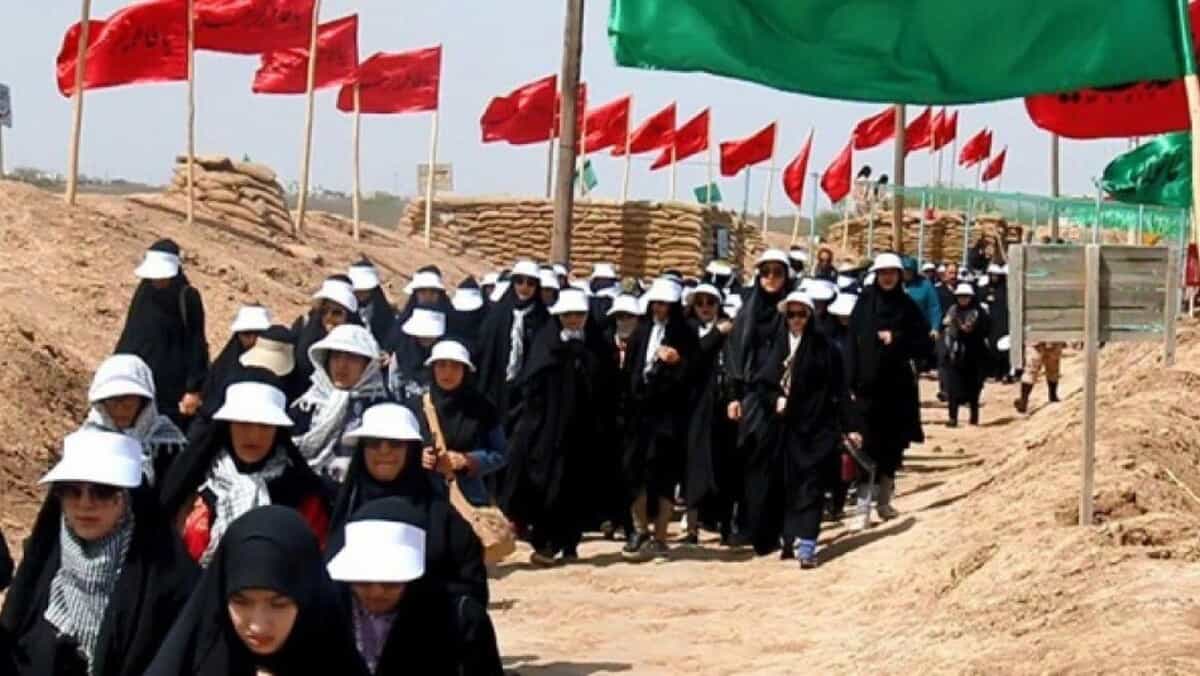 تصویری از اردوی راهیان نور - صف دختران داش آموز در میان پرچم های رنگی