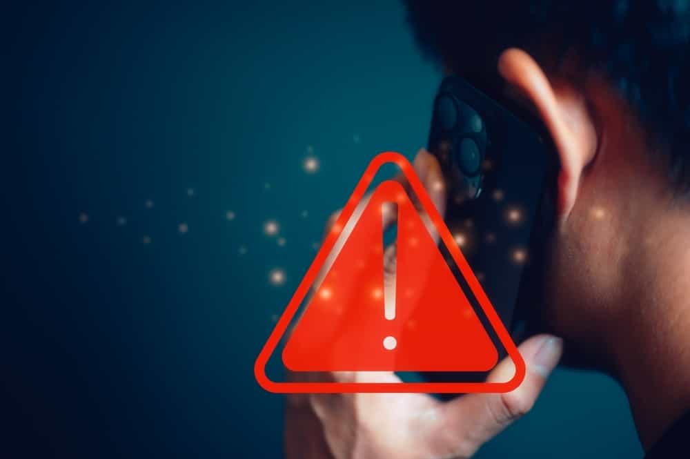 مردی در حال صحبت با موبایل. علامت خطر قرمز رنگ روی عکس