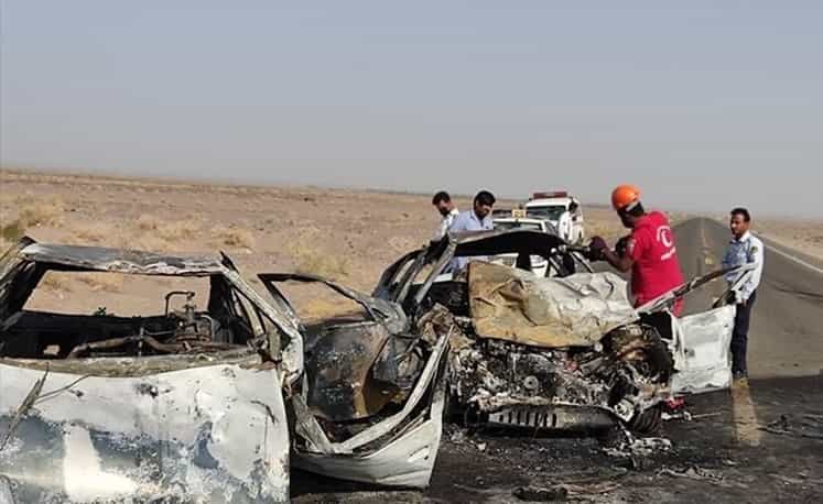 دو خودرو بر اثر تصادف آتش گرفتهاند و تنها تکههای آهن از آنها باقی مانده است. ماموران امداد و نجات هم در صحنه حاضرند