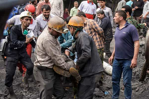 کارگران معدن یک کارگر را که دچار سانحه کاری شده از محل حادثه بیرون می‌کشند.