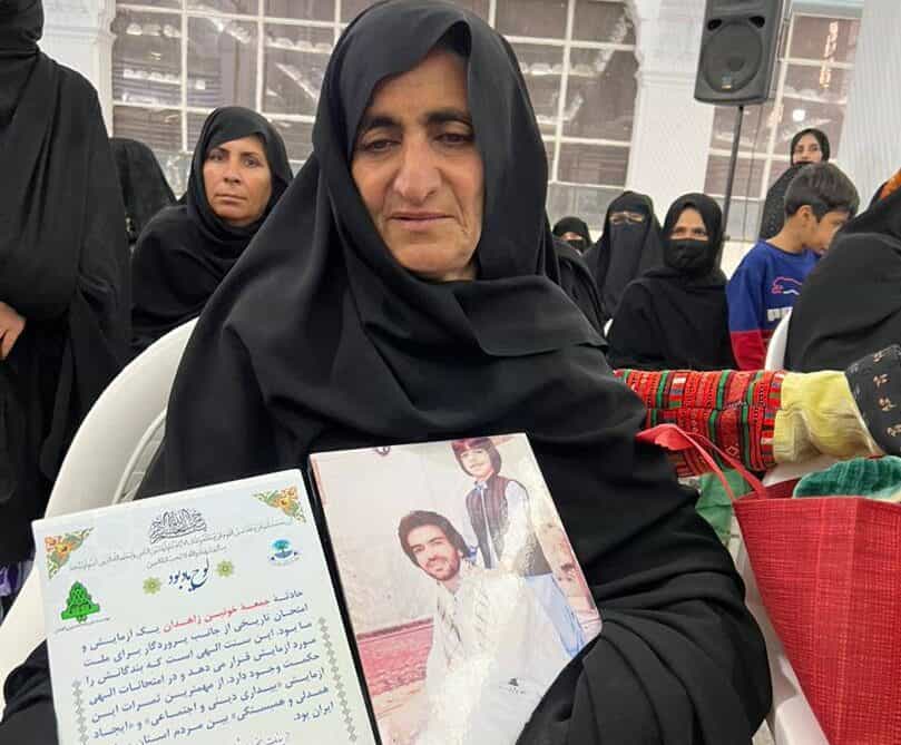 تصویری از سنوبر، مادر خدانور لجهای در حالی که عکس فرزندش را در دست دارد