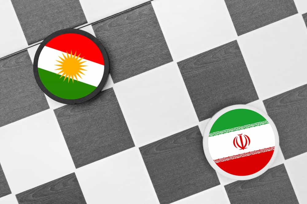 مهره به رنگ پرچم ایران و مهرهای به رنگ پرچم کردستان بر یک صفحه شطرنج