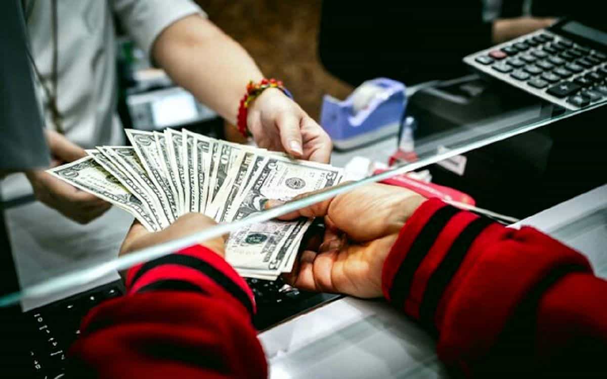 تصویری از یک صرافی که در آن دو نفر با هم دلار رد و بدل میکنند