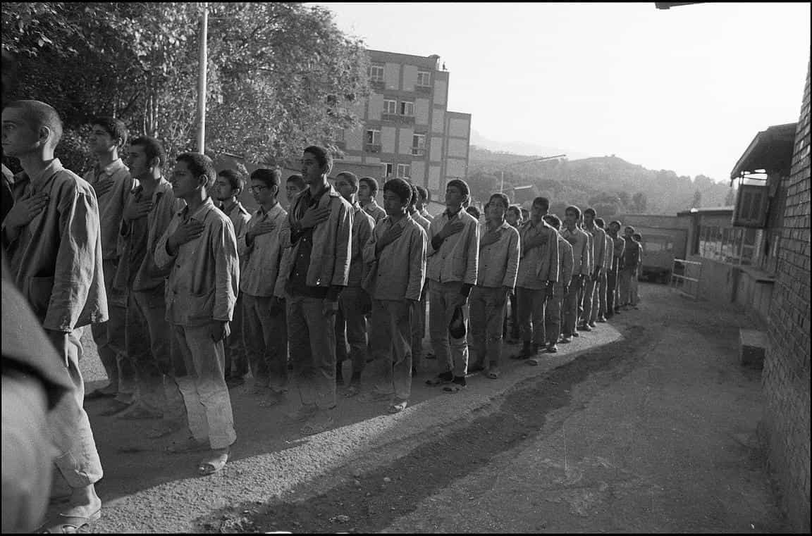 عد‌ه‌ای نوجوان، زندانی سیاسی در اوین، ابتدای دهه ۱۳۶۰، وادارشان کرده‌اند سینه بزنند و از نمایش جنگی بسیجی‌ها تقلید کنند. عکس از آلفرد یعقوب‌زاده