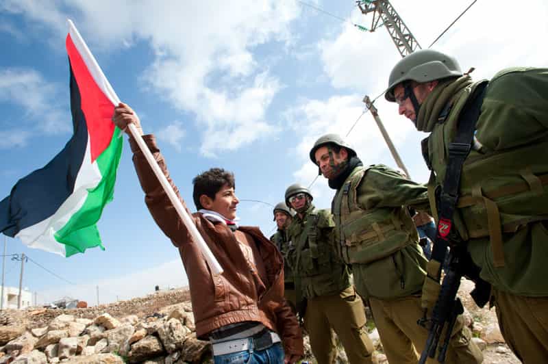 یک فلسطینی ساکن سرزمینهای اشغالی در برابر سربازان اسرائیلی