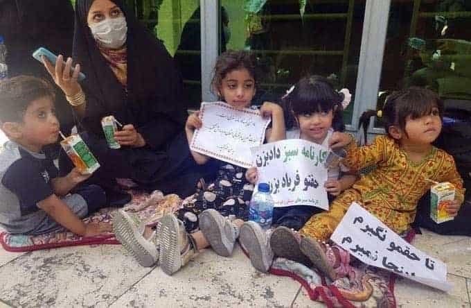یک معلم از استان سیستان و بلوچستان همراه با کودکان خود در پیادهرو جلوی وزارت آموزش و پرورش، ۶ تیر ۱۴۰۰، عکس از سایت ایران کارگر