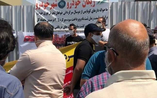 دهم تیر ۱۳۹۹: غارت شدگان شرکت ریگان خودرو و شهر خودرو با تجمع در مقابل دفتر این شرکت واقع در جاده مخصوص کرج خواستار تعیین تکلیف خودروهای خود شدند − عکس از شبکههای اجتماعی