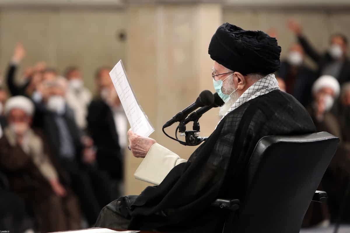 عکسی از زاویه پشت سر خامنهای در حالی که کاغذی در دست دارد و به آن نگاه میکند