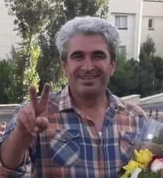 اسکندر لطفی پس از آزادی با دسته گل در دست و پیراهن چهارخانه آبی و گلبهی