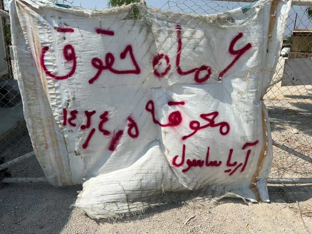 پارچهنوشته روی کیسه: «شش ماه حقوق معوقه؛ آریا ساسول»