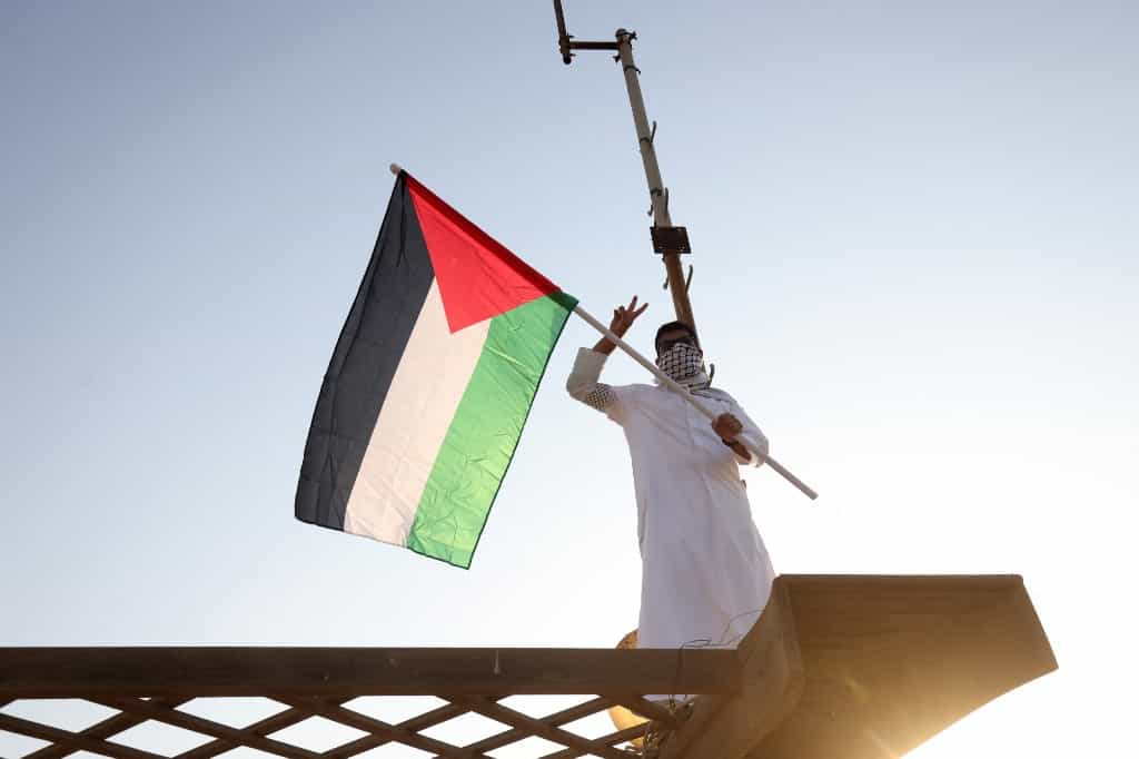 مردی کویتی در حمایت از فلسطین پرچم فلسطینیها را تکان میدهد، هفتم اکتبر ــ عکس: Yasser Al-Zayyat / AFP