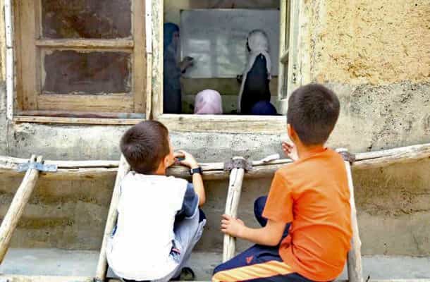 بازماندگی از تحصیل - دو کودک از پنجره به داخل یک کلاس درس نگاه میکنند