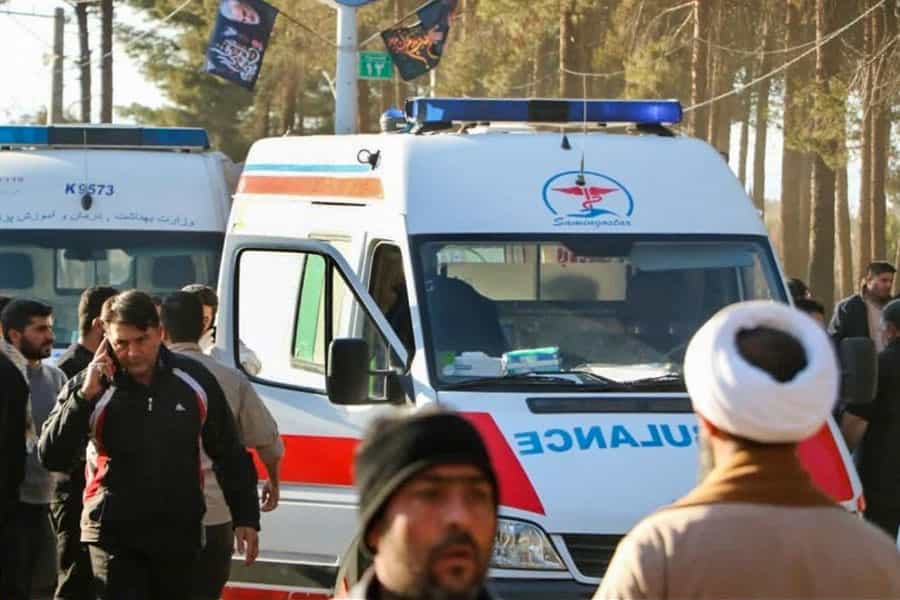 در تصویر دو آمبولانس و مردمی که دور و بر آن‌ها هستند دیده می‌شوند. یک نفر دارد با تلفن همراه حرف می‌زند. یک آخوند هم دیده می‌شود.
