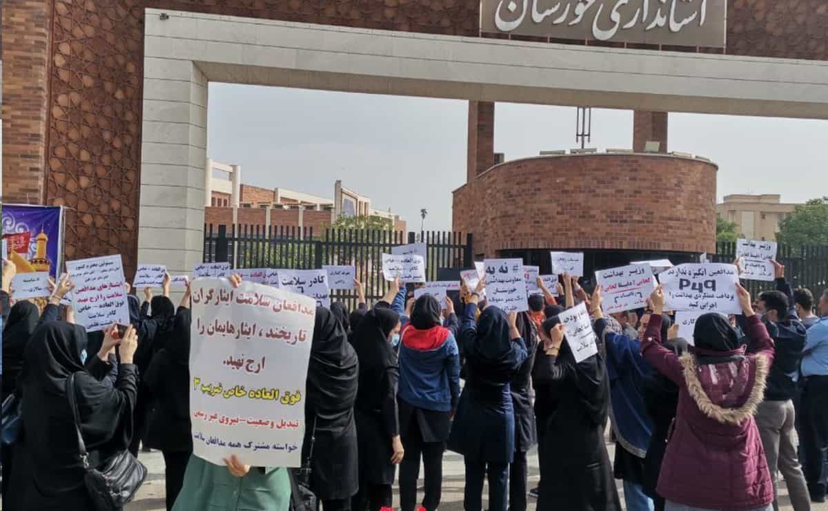 ده‌ها پرستار در برابر استانداری خوزستان پلاکاردهای مختلفی در دست گرفته اند