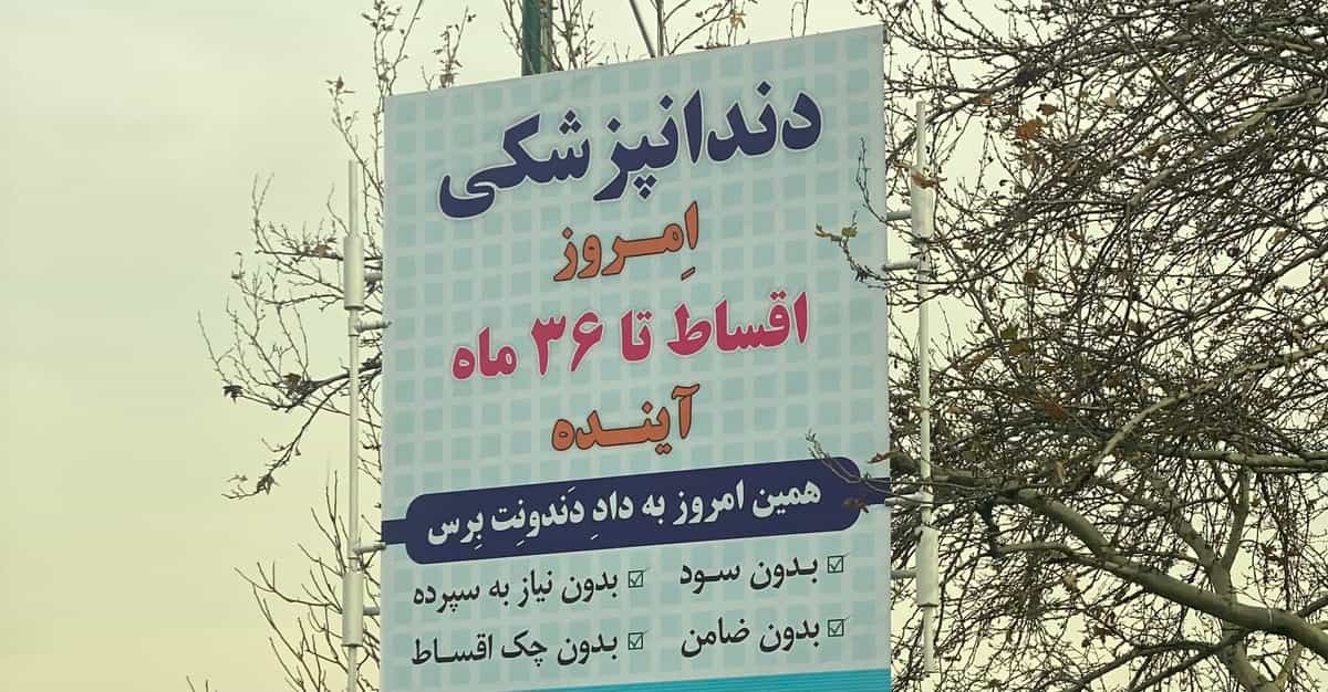 بنر تبلیغ دندانپزشکی. بروی روی آن نوشته شده: دندانپزشکی امروز اقساط تا ۳۶ ماه آینده. همین امروز به داد دندونت برس. بدون سود، بدون سپرده، بدون ضامن، بدون چک اقساط