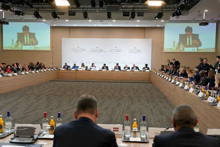 نمایندگان کنفرانس بینالمللی سودان در پاریس پشت یک میز بزرگ دور تا دور سالن کنفرانس نشستهاند.