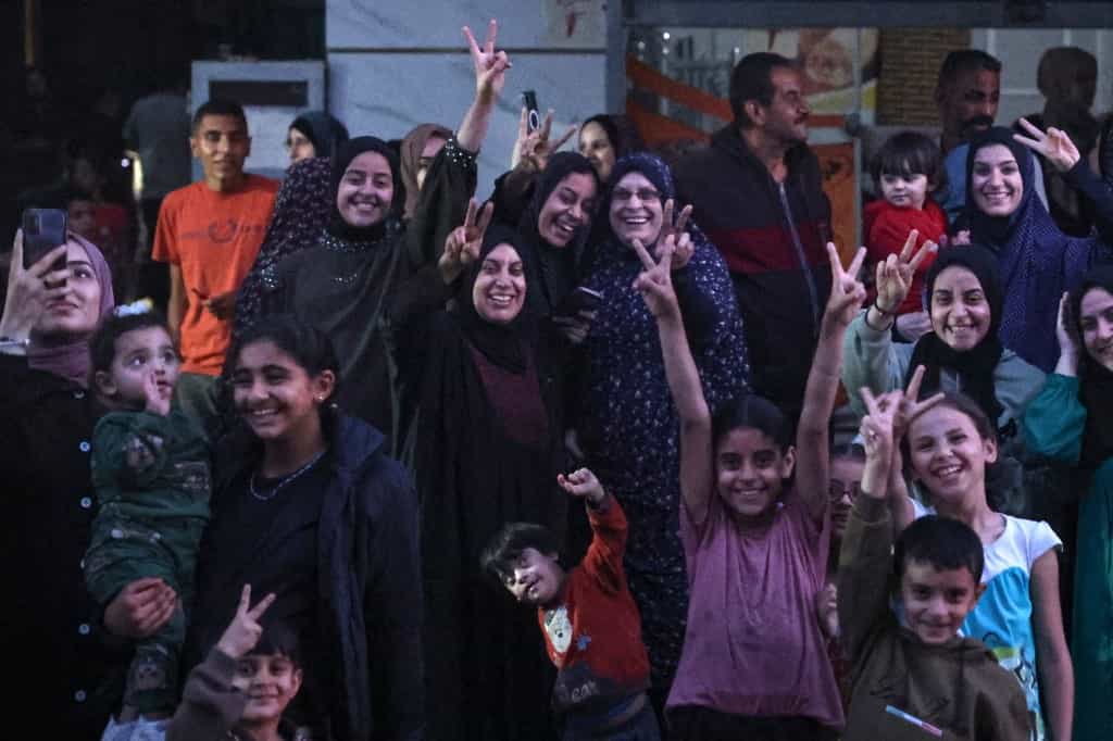 شماری کودک و زن در حال نشان دادن وی و خندیدن