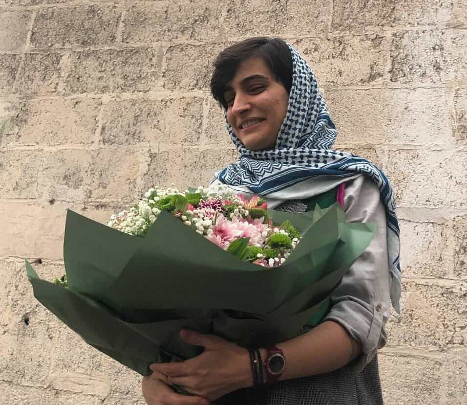 الهه محمدی جامانه بر سر و دستگل بزرگی در دست