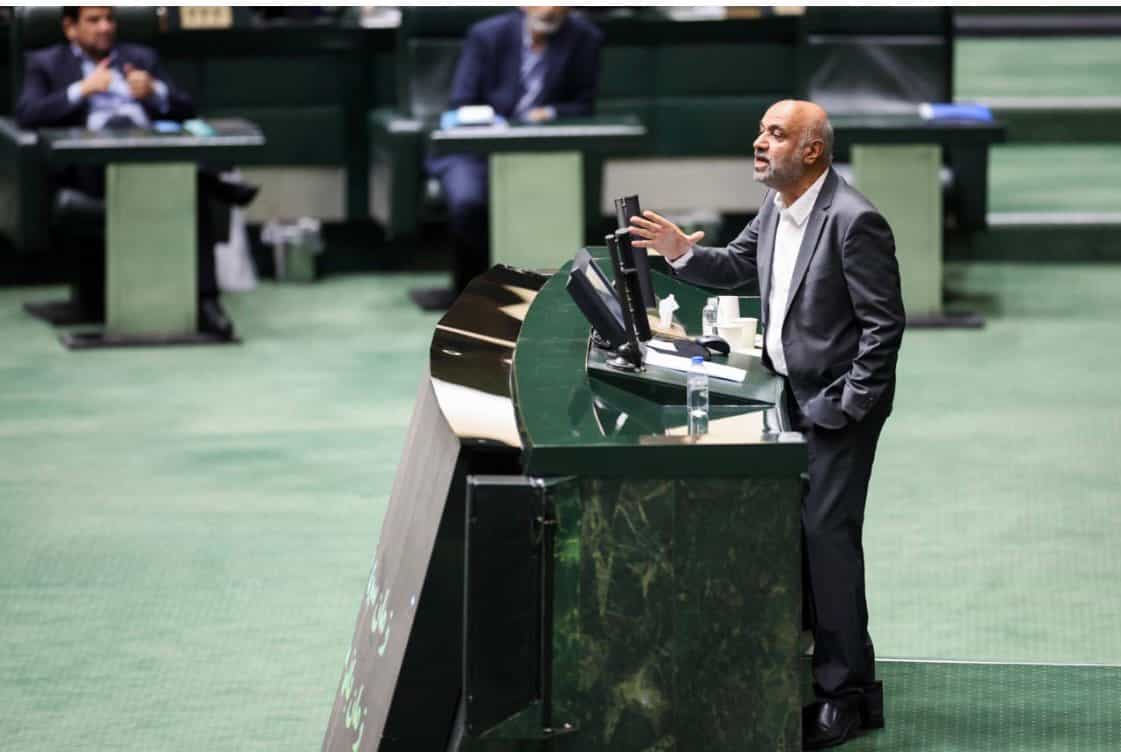 احمد میدری، وزیر تعاون، کار ور فاه اجتماعی در صحن علنی مجلس. یک دستش را در جیب شلوار گذاشته و با یک دست دیگر با نمایندگان حرف میزند.