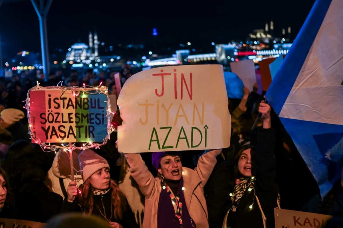 معترضان در تظاهرات روز جهانی رفع خشونت علیه زنان، در نزدیکی خیابان استقلال در استانبول در تاریخ ۲۵ نوامبر ۲۰۲۴، پلاکاردهایی با نوشته‌های «ژن، ژیان، ئازادی» و «کنوانسیون استانبول شما را زنده نگه می‌دارد» در دست دارند. (عکس از کمال اصلان / خبرگزاری فرانسه)