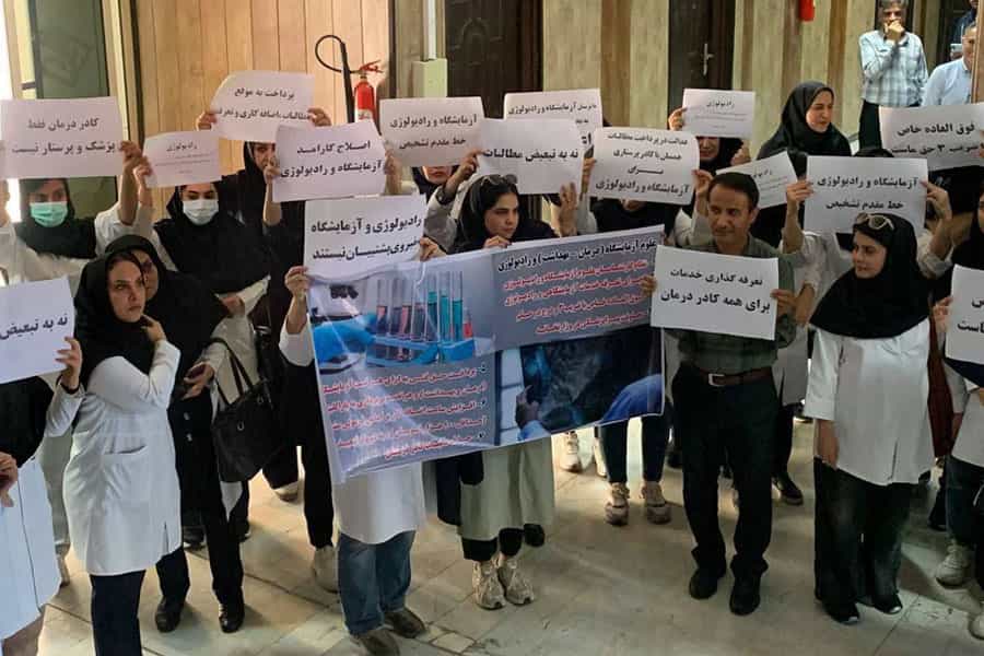پرستاران بخشهای آزمایشگاه و رادیولوژی بوشهر پلاکاردهای که روی آنها خواستههای خود را نوشتهاند در دست دارند.