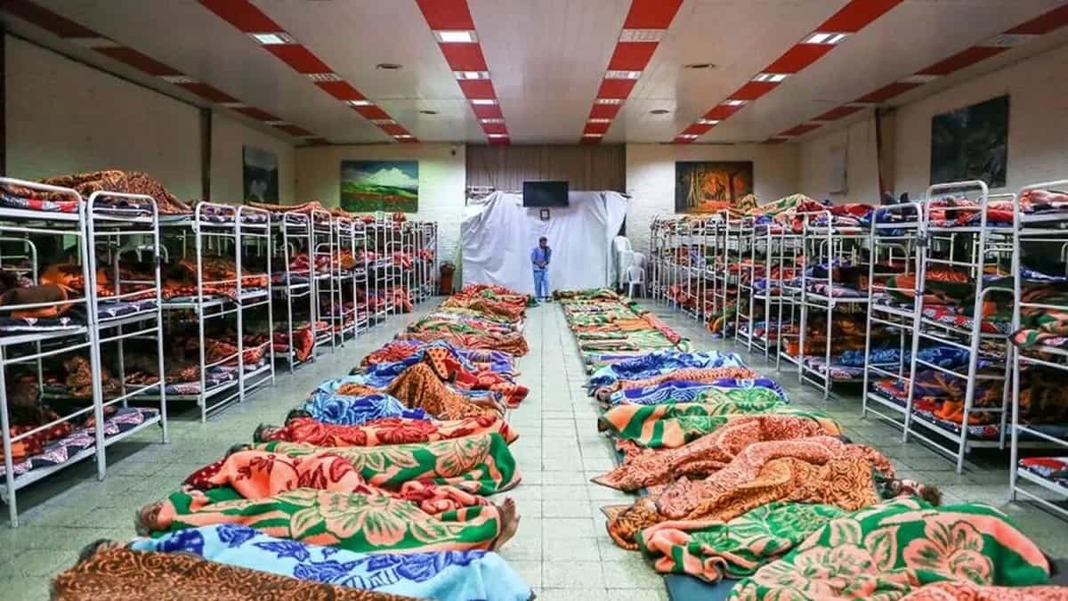 یک گرمخانه احتمالا در تهران که تعداد زیادی در آن روی زمین و تختهای دو طبقه خوابیده اند.