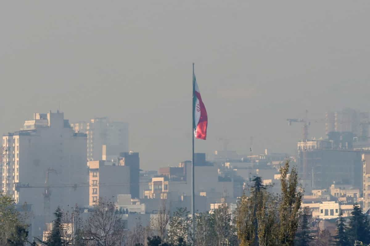 تصویر خبرگزاری فرانسه از آلودگی شدید هوا در تهران، پرچم جمهوری اسلامی را کم‌توان نشان می‌دهد.