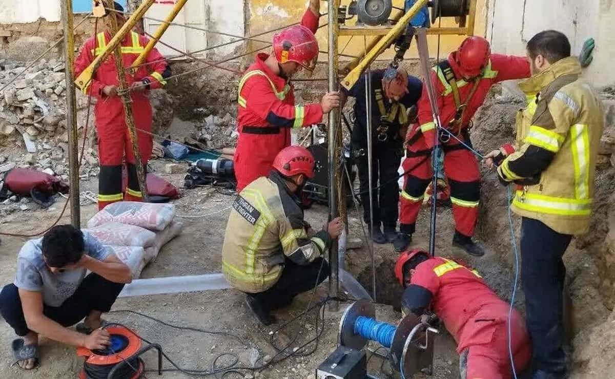 آتش نشانهایی که یک کارگر را از چاه بیرون می آورند