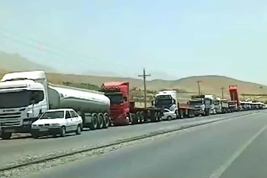 در اتوبانی ده‌ها کامیون پشت سر هم قرار گرفته‌اند.