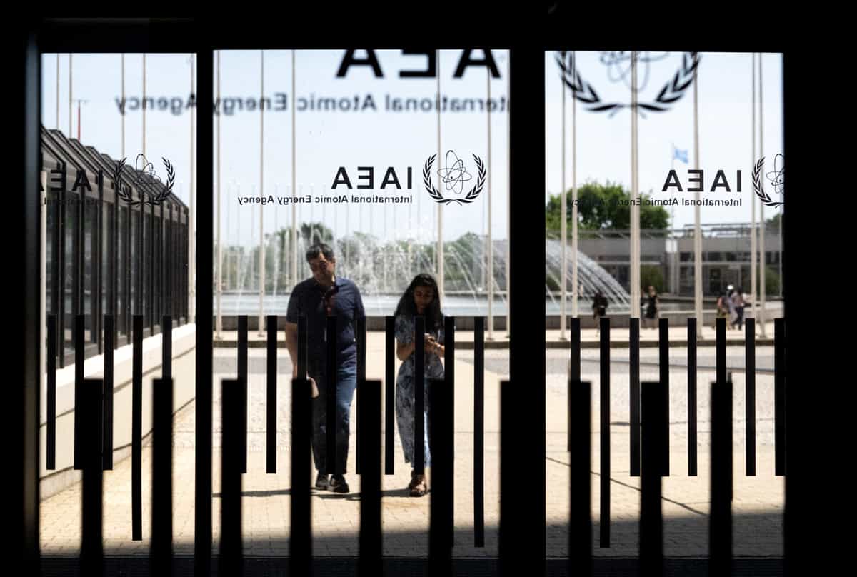 افراد در تاریخ ۱۳ ژوئن ۲۰۲۵ به آژانس بین‌المللی انرژی اتمی (IAEA) در وین، اتریش وارد می‌شوند، در حالی که جلسه هیئت مدیره به‌صورت غیرعلنی برگزار می‌شود. در این جلسه، رافائل گروسی، رئیس آژانس، اعضای هیئت را پس از حملات اسرائیل به ایران، از جمله تأسیسات غنی‌سازی اورانیوم نطنز، مطلع کرد. (عکس از جو کلامار / خبرگزاری فرانسه)