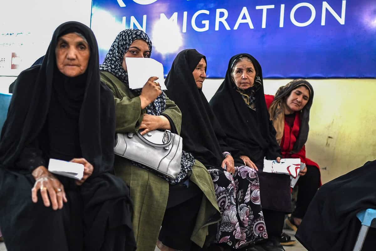 زنان پناهنده افغان که از ایران اخراج شده‌اند، در مرکز ثبت نام سازمان بین‌المللی مهاجرت (IOM) در هرات، در تاریخ ۲۸ ژوئن ۲۰۲۵، منتظر دریافت پول هستند.
