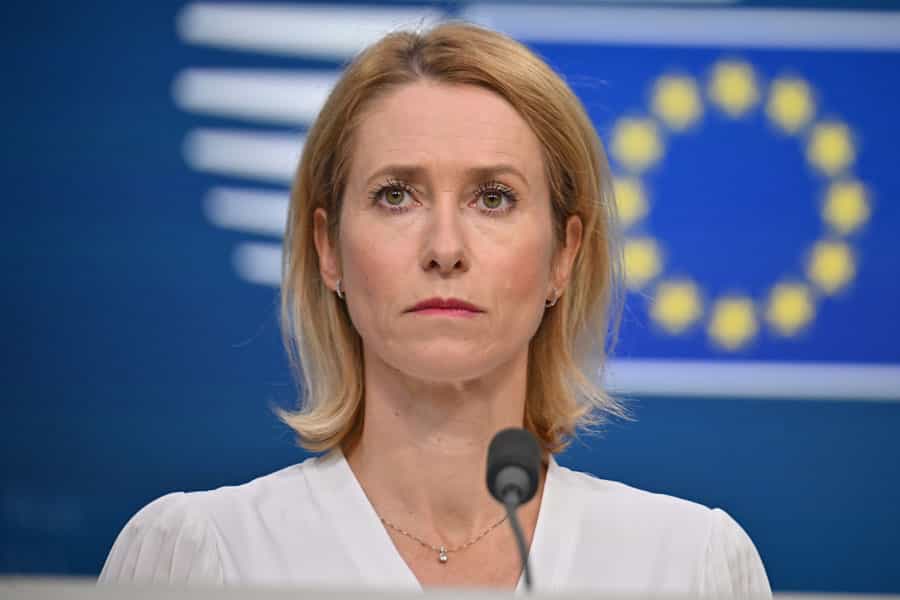 تصویری از چهره کایا کالاس. پشت سر او لوگوی اتحادیه اروپا با ستاره‌های زرد آن روی پسزمینه آبی‌رنگ دیده می‌شود.