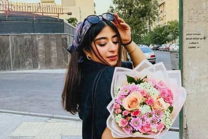در این تصویر پرنیا عباسی در حالی‌که بی‌حجاب است و یک عینک دودی بر سر دارد دسته‌گلی در دسته دارد و به آن نگاه می‌کند.