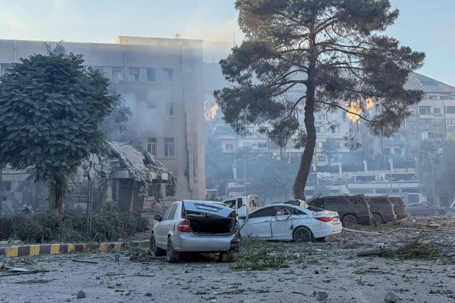 یک ساختمان در آتش میسوزد و چند خودرو در خیابان در میان دود ناشی از انفجار متلاشی شدهاند.