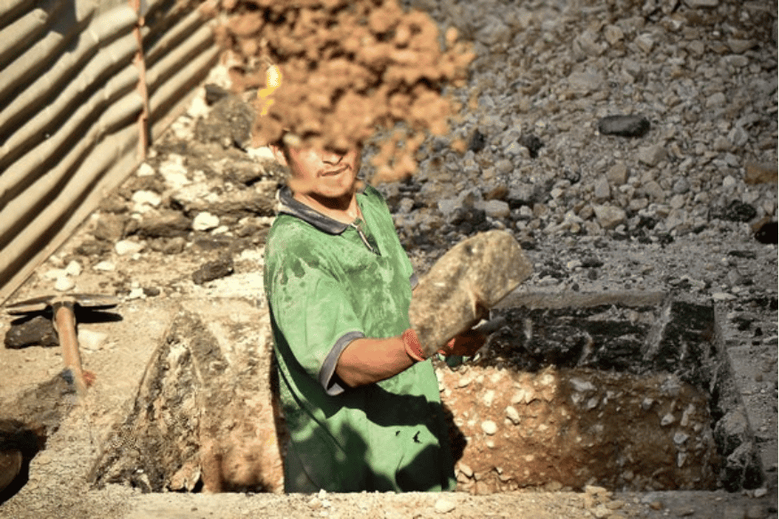 کارگری در حال کندن یک گودال است.