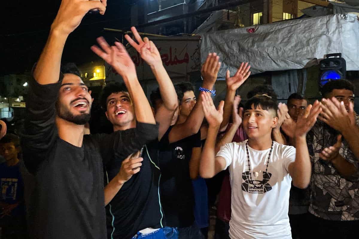 چند جوان و نوجوان فلسطینی در حال رقص و پایکوبی هستند.